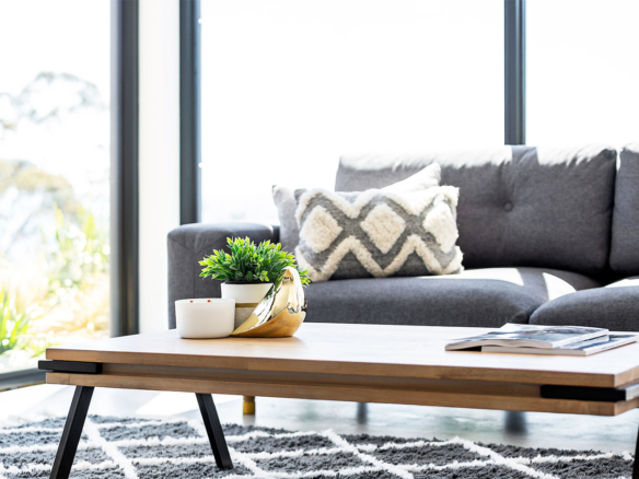 Bright living room with modern wooden coffee table and cozy gray couch.