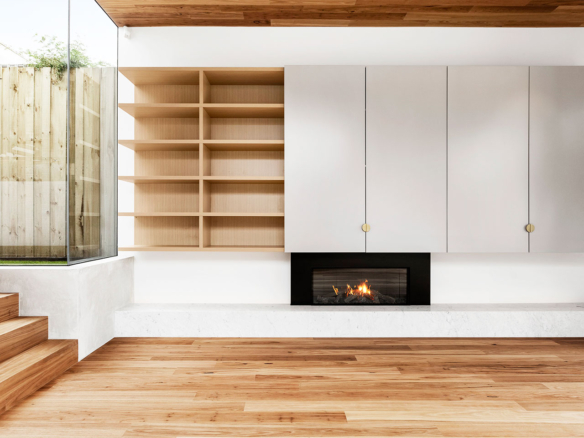 Modern living room with a built-in fireplace and wooden shelves.