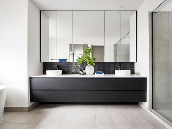 Modern bathroom with double sinks and large mirrors.