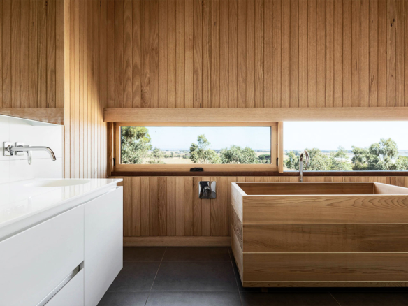 Modern bathroom with wood accents and a scenic window view.