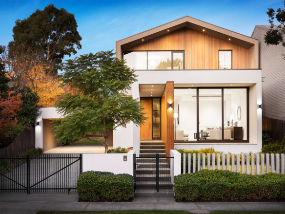 Modern two-story home with large windows and wooden accents.