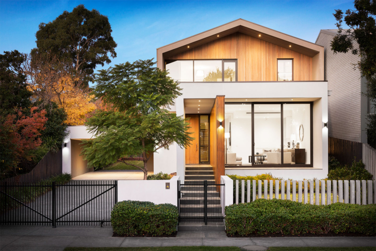 Modern two-story home with large windows and wooden accents.