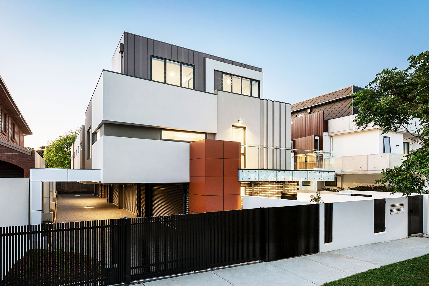 Modern multi-story house with clean lines and large windows at dusk.