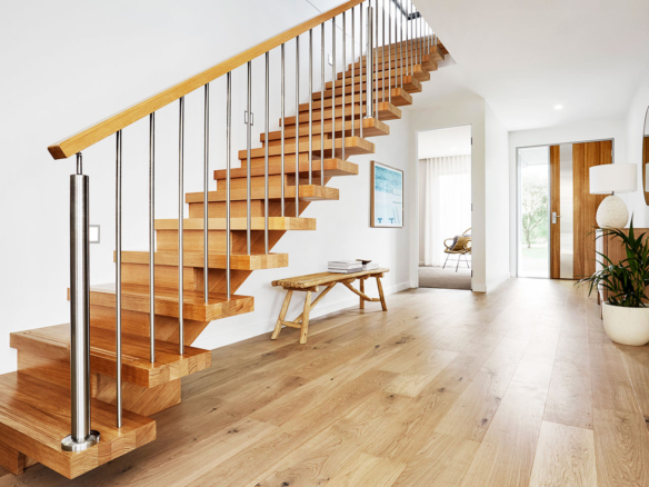 Modern wooden staircase with metal railings in a bright home.