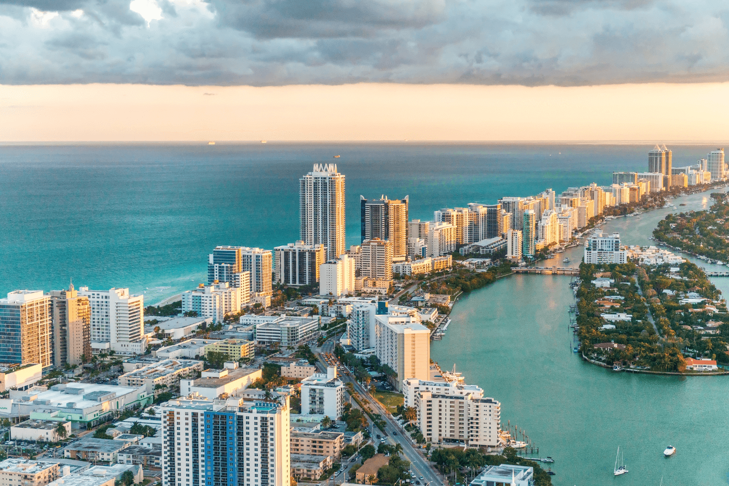 Aerial view of a coastal city with tall buildings and a waterway.