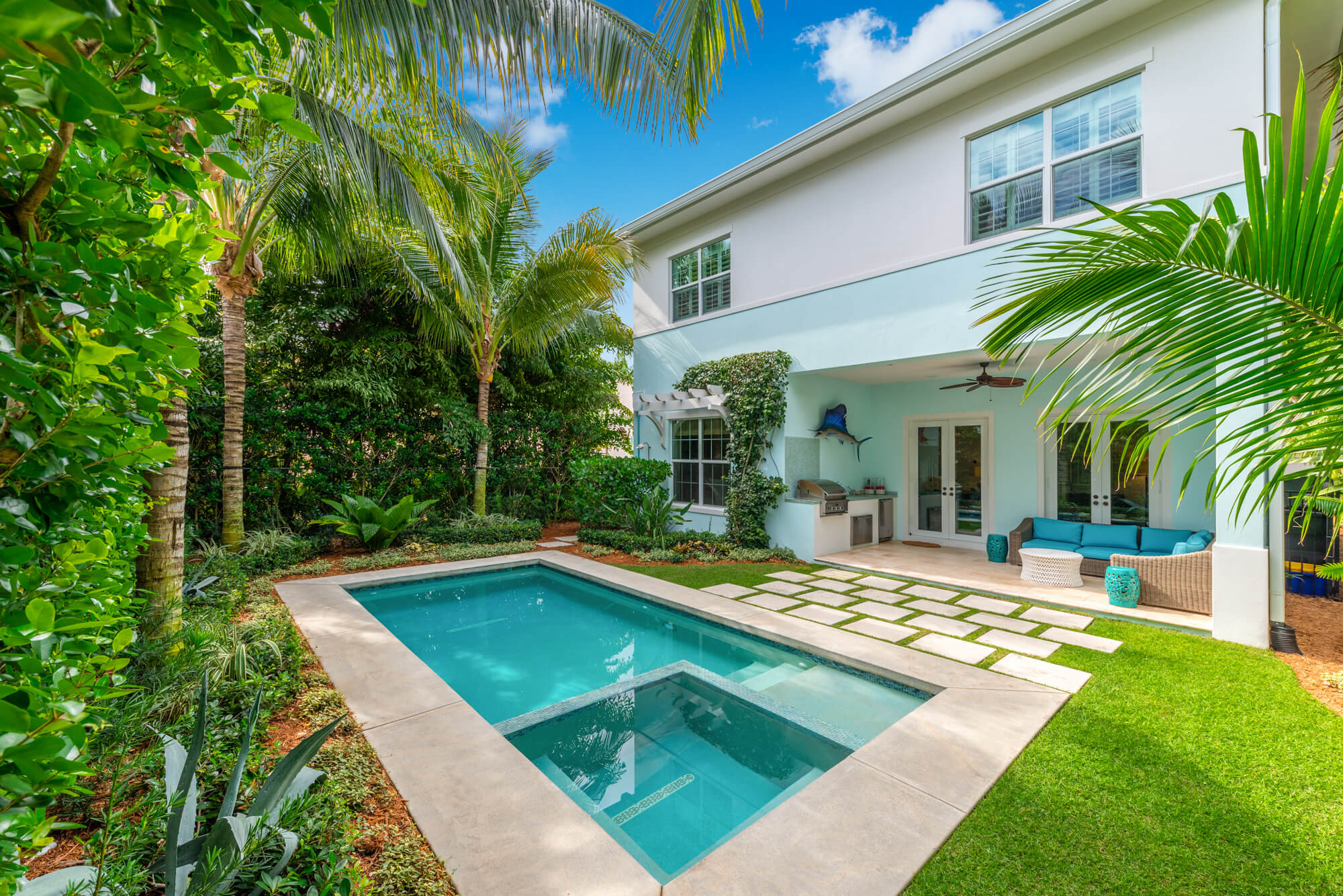 Modern backyard with a small pool and lush greenery.