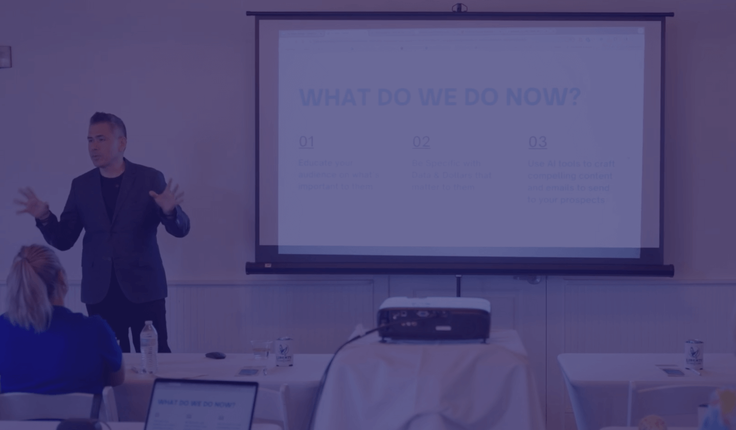 Person giving a presentation with slides on a projector screen.