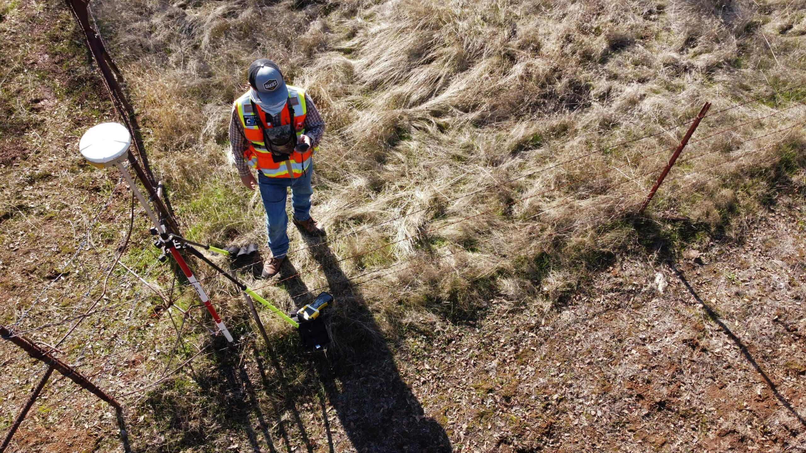Person wearing safety gear inspecting equipment outdoors.
