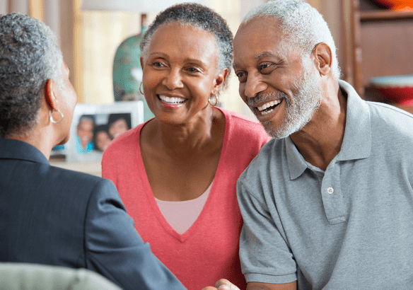 Happy senior couple smiling during a conversation with a professional.