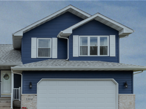 Two-story suburban house with blue siding and a white garage door.