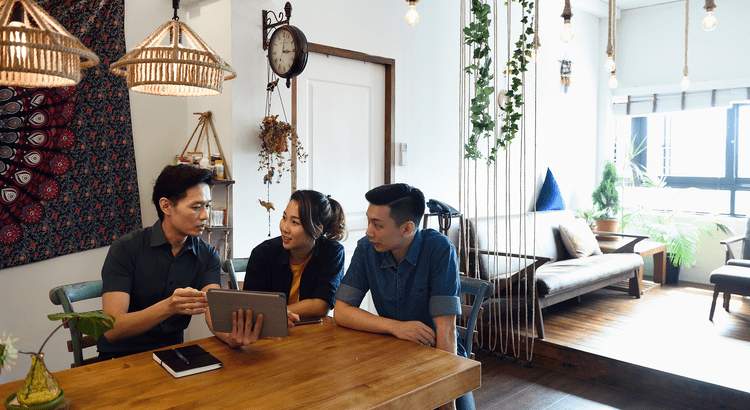 People discussing with tablet in cozy room.