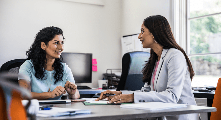 Two women having a meeting at desk.
