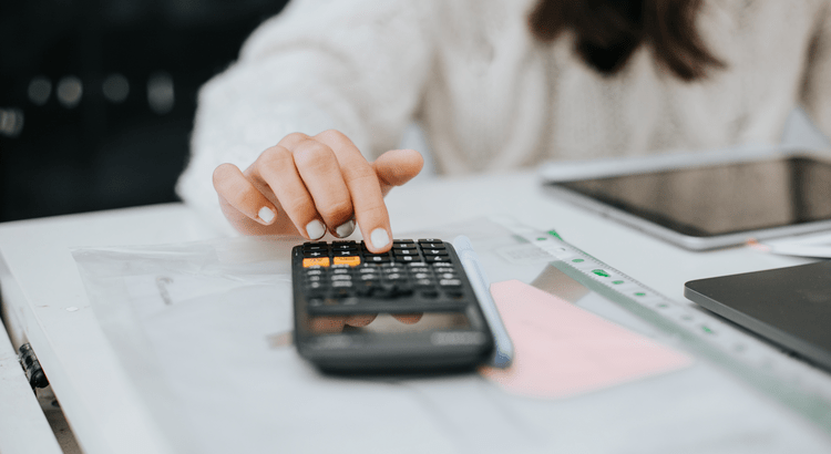 Person using calculator on a desk.