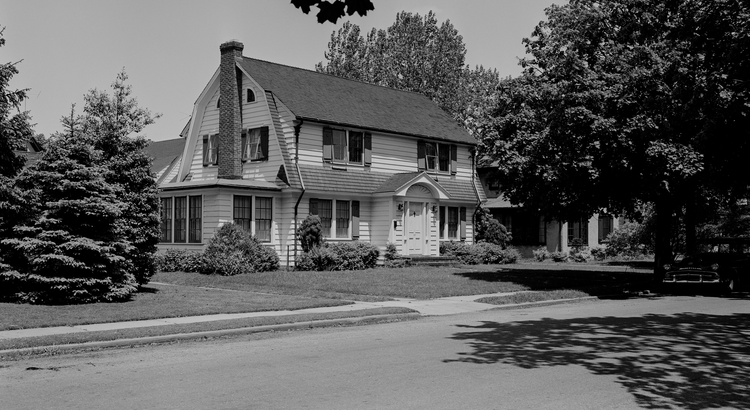 Colonial-style house with trees and yard.