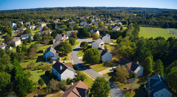 Aerial view of suburban neighborhood and greenery.