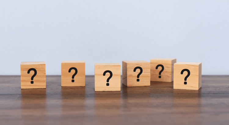 Wooden blocks with question marks in row.
